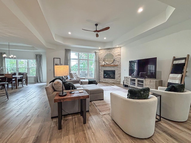 1601 Sauk Trl, Waukesha, WI 53189 - living room with a raised ceiling, ceiling fan, light wood-type flooring, a stone fireplace, and recessed lighting