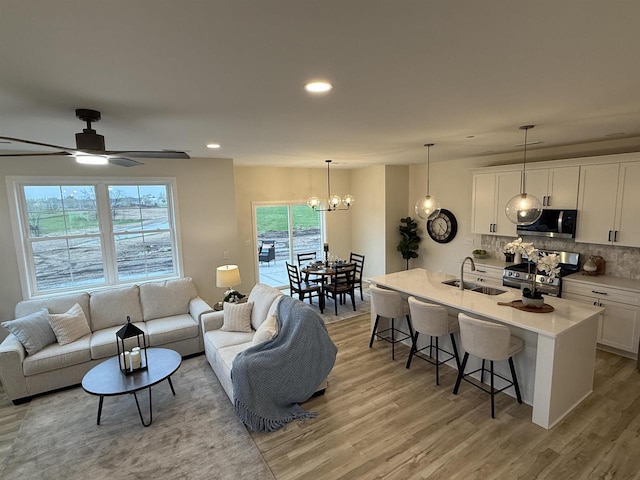 3150 Bartells Dr, Beloit, WI 53511 - living room with light wood-style floors, recessed lighting, a chandelier, and ceiling fan