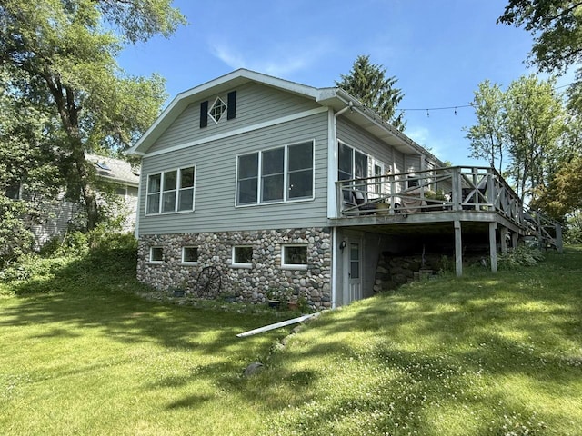 N65W35097 Rd J, Oconomowoc, WI 53066 - rear view of house with a wooden deck, a yard, and stone siding