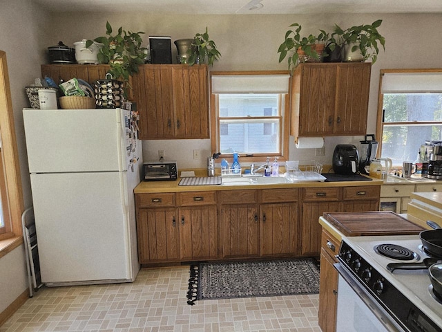 N65W35097 Rd J, Oconomowoc, WI 53066 - kitchen featuring white appliances, light countertops, and brown cabinetry
