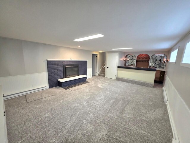 4643 N 108th St, Wauwatosa, WI 53225 - carpeted living area with baseboard heating, stairs, a brick fireplace, and a wainscoted wall