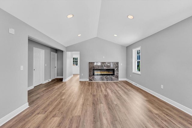 7314 25th Ave, Kenosha, WI 53143 - unfurnished living room with vaulted ceiling, a premium fireplace, wood finished floors, and recessed lighting
