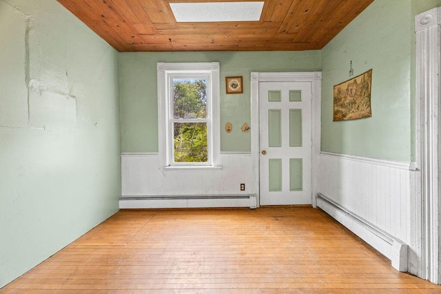 5046 State Highway 33, West Bend, WI 53095 - empty room with a baseboard heating unit, wainscoting, light wood-style floors, and wood ceiling