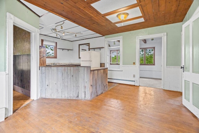 5046 State Highway 33, West Bend, WI 53095 - kitchen with freestanding refrigerator, a baseboard radiator, wainscoting, hardwood / wood-style flooring, and wooden ceiling
