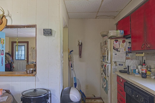 134 N Watertown St, Waupun, WI 53963 - kitchen featuring red cabinetry, black dishwasher, a paneled ceiling, and light countertops