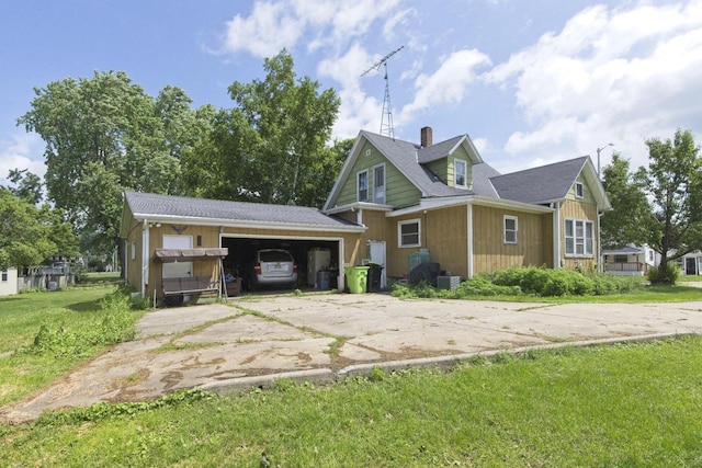 134 N Watertown St, Waupun, WI 53963 - view of front of house featuring concrete driveway, a front yard, a chimney, and a garage