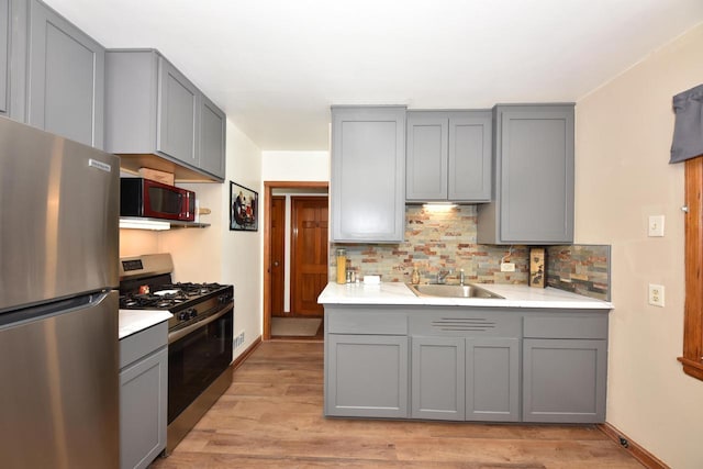 2044 S 96th St, West Allis, WI 53227 - kitchen featuring stainless steel appliances, gray cabinets, decorative backsplash, and light wood finished floors