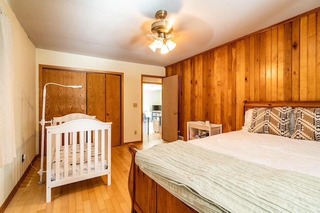 E2880 Witcraft Ridge Rd, Genoa, WI 54632 - bedroom featuring light wood finished floors, wood walls, a closet, and a ceiling fan