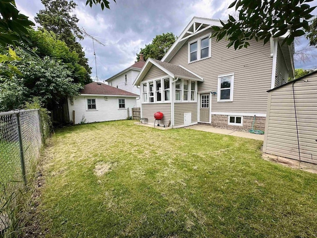 110 Bowen St, Oshkosh, WI 54901 - back of property featuring a fenced backyard, a sunroom, and a patio area