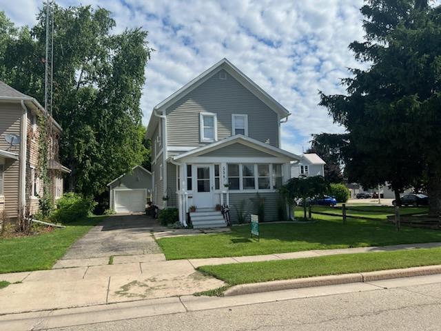 556 E Jefferson St, Waupun, WI 53963 - view of front of home featuring an outbuilding, driveway, a front yard, a detached garage, and entry steps