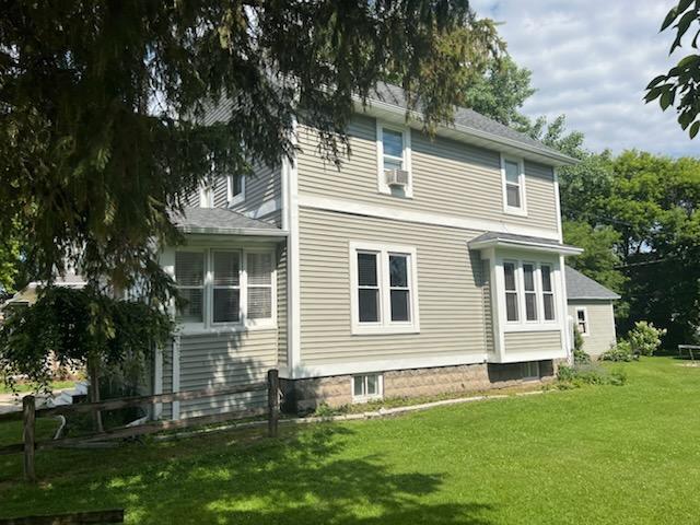 556 E Jefferson St, Waupun, WI 53963 - rear view of house with a lawn and cooling unit