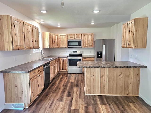 1209 E 15th St, Marshfield, WI 54449 - kitchen with stainless steel appliances, dark countertops, dark wood-type flooring, and a peninsula