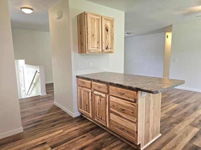 1209 E 15th St, Marshfield, WI 54449 - kitchen featuring a peninsula, dark countertops, dark wood-style floors, and light brown cabinetry