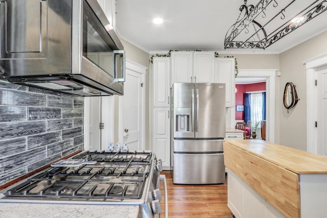 822 12th Ave, Union Grove, WI 53182 - kitchen featuring appliances with stainless steel finishes, butcher block counters, white cabinetry, light wood-style floors, and tasteful backsplash
