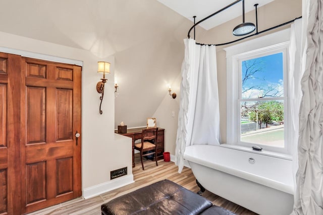 822 12th Ave, Union Grove, WI 53182 - bathroom with a freestanding tub, wood finished floors, and vaulted ceiling