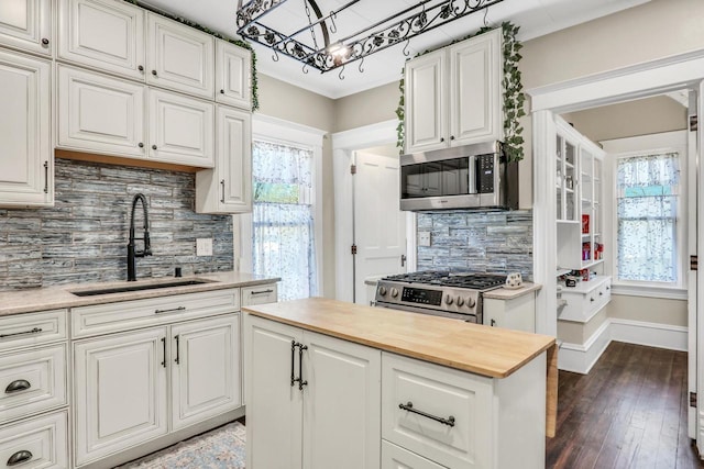 822 12th Ave, Union Grove, WI 53182 - kitchen featuring appliances with stainless steel finishes, butcher block countertops, decorative backsplash, white cabinets, and healthy amount of natural light