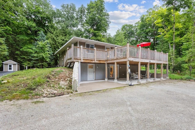 6170 Bay Shore Dr, Sturgeon Bay, WI 54235 - view of front of property with a wooden deck, a patio area, and an outdoor structure