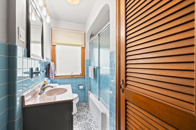 1240 Franklin St, Wisconsin Rapids, WI 54494 - bathroom featuring vanity, healthy amount of natural light, bath / shower combo with glass door, tile walls, and tile patterned flooring