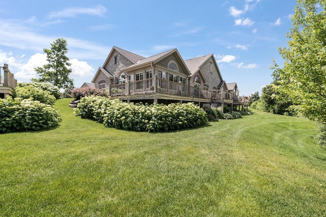 1040 Ann Marie Way, Oconomowoc, WI 53066 - back of house featuring a wooden deck, a yard, and stone siding