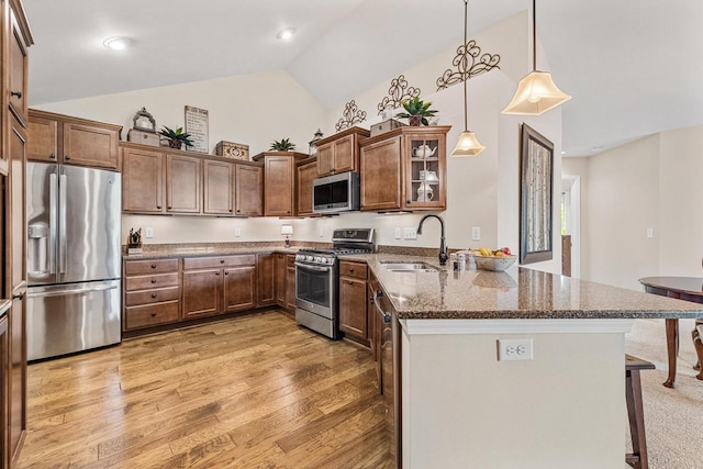 1040 Ann Marie Way, Oconomowoc, WI 53066 - kitchen featuring appliances with stainless steel finishes, a peninsula, a kitchen breakfast bar, dark stone countertops, and glass insert cabinets