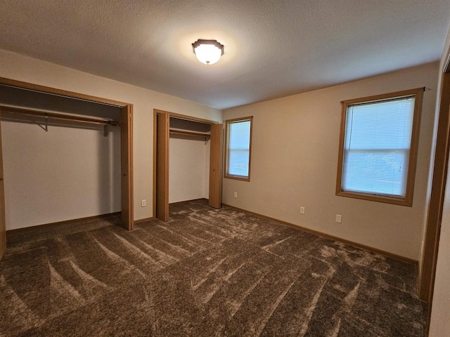 105 W Clark St, Plainfield, WI 54966 - unfurnished bedroom featuring multiple closets and dark carpet