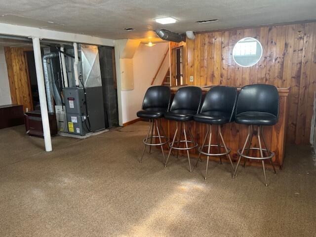 3681 S 5th St, Milwaukee, WI 53207 - indoor dry bar with stairway, carpet flooring, heating unit, wood walls, and a textured ceiling