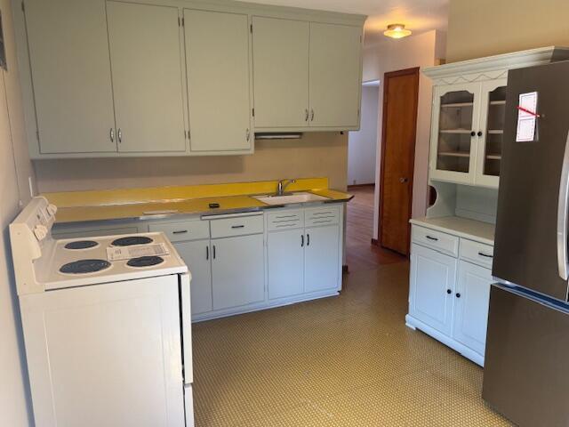 3681 S 5th St, Milwaukee, WI 53207 - kitchen featuring white electric stove, freestanding refrigerator, light countertops, light floors, and glass insert cabinets