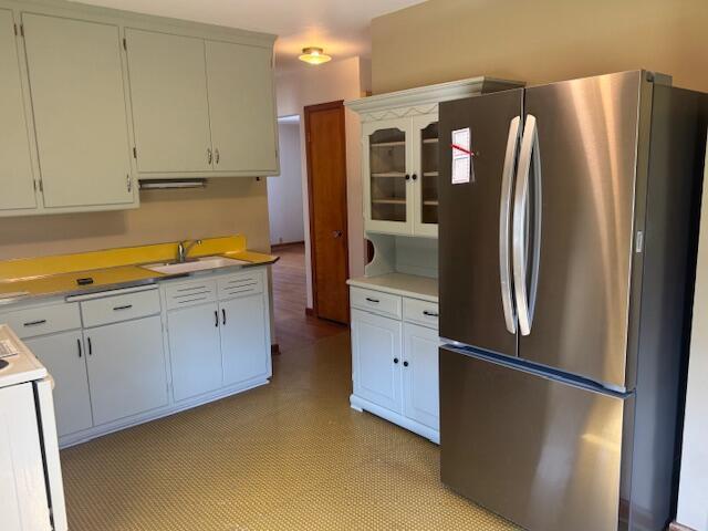 3681 S 5th St, Milwaukee, WI 53207 - kitchen featuring freestanding refrigerator, stove, white cabinets, light countertops, and glass insert cabinets
