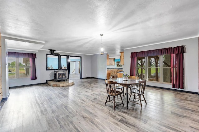 5836 County Road V, Gillett, WI 54124 - dining area featuring a wood stove, wood finished floors, crown molding, and a textured ceiling