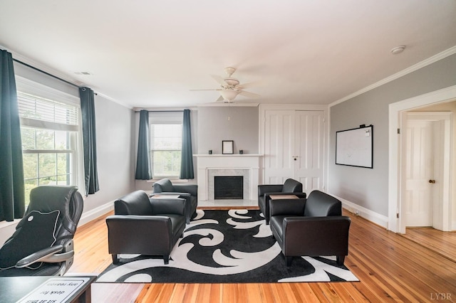 7821 Bellevue Rd, Forest, VA 24551 - living area with light wood finished floors, a fireplace with raised hearth, baseboards, crown molding, and a ceiling fan
