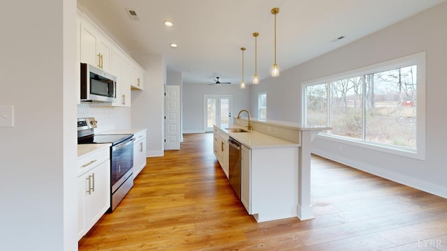 165 Allure Dr, Rustburg, VA 24588 - kitchen featuring stainless steel appliances, white cabinets, light countertops, a center island with sink, and pendant lighting