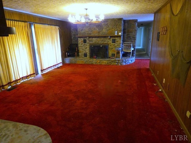 11420 Wards Rd, Rustburg, VA 24588 - carpeted living room featuring a textured ceiling, wooden walls, a fireplace, and a chandelier