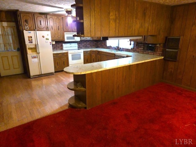 11420 Wards Rd, Rustburg, VA 24588 - kitchen with white appliances, a peninsula, light countertops, and brown cabinetry
