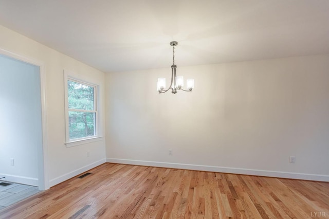 465 Soybean Dr, Appomattox, VA 24522 - spare room featuring a chandelier, light wood-style flooring, and baseboards