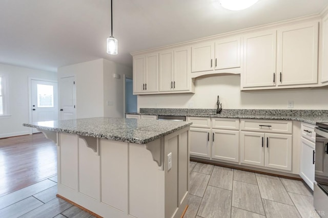 465 Soybean Dr, Appomattox, VA 24522 - kitchen featuring a sink, light wood finished floors, a center island, light stone counters, and a breakfast bar