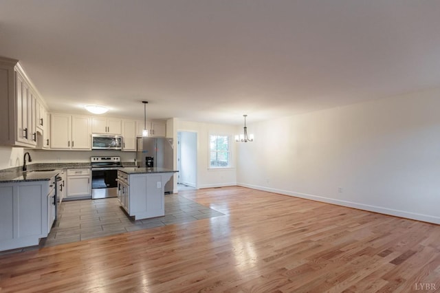 465 Soybean Dr, Appomattox, VA 24522 - kitchen with stainless steel appliances, a chandelier, light wood-type flooring, a kitchen island, and pendant lighting