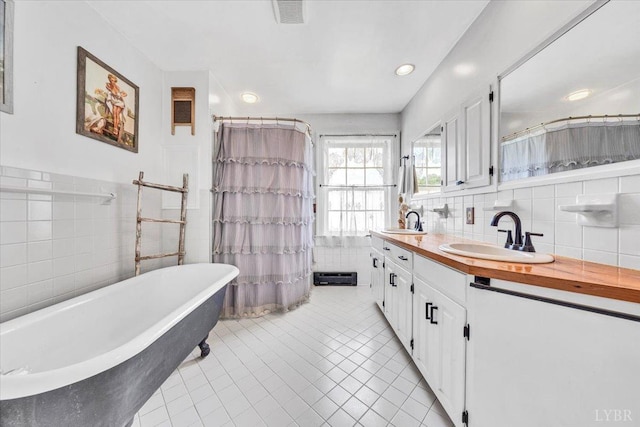 2816 Lowesville Rd, Lowesville, VA 22922 - full bathroom featuring tile walls, a soaking tub, double vanity, tile patterned flooring, and wainscoting