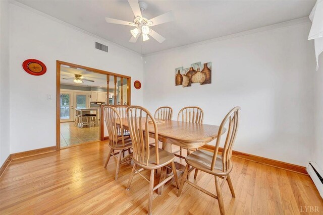 dining room with ceiling fan, a baseboard heating unit, ornamental molding, and light tile patterned floors