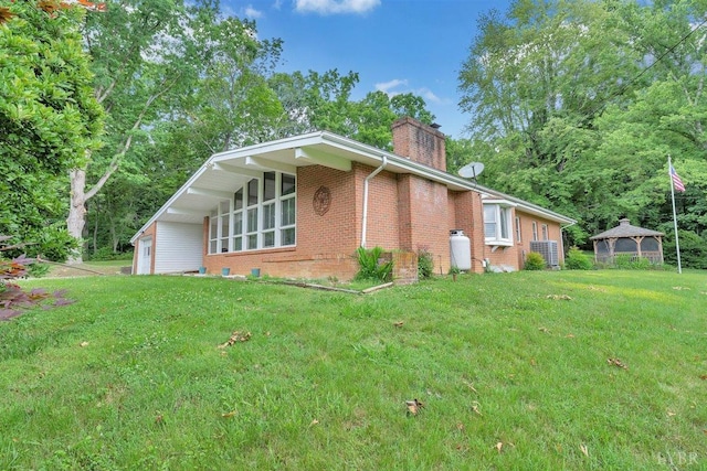 view of side of property with a gazebo and a lawn