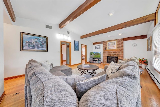 living room with baseboard heating, light wood-type flooring, lofted ceiling with beams, and a brick fireplace