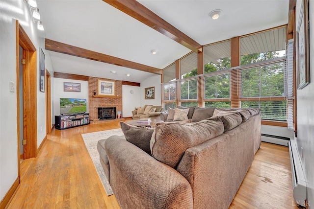 living room featuring light hardwood / wood-style flooring, a fireplace, and vaulted ceiling with beams