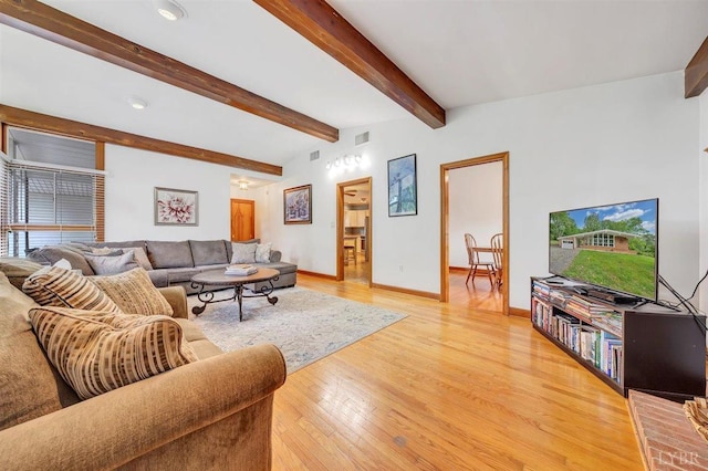 living room with beamed ceiling and light wood-type flooring