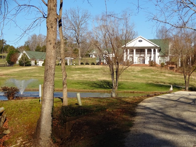 surrounding community with a water view and a yard