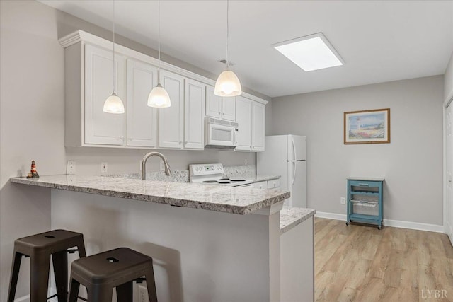 1055 Mariners Way, Huddleston, VA 24104 - kitchen with white appliances, a sink, a peninsula, a breakfast bar area, and light wood-style floors