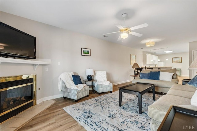 1055 Mariners Way, Huddleston, VA 24104 - living area with a tile fireplace, wood finished floors, baseboards, and a ceiling fan