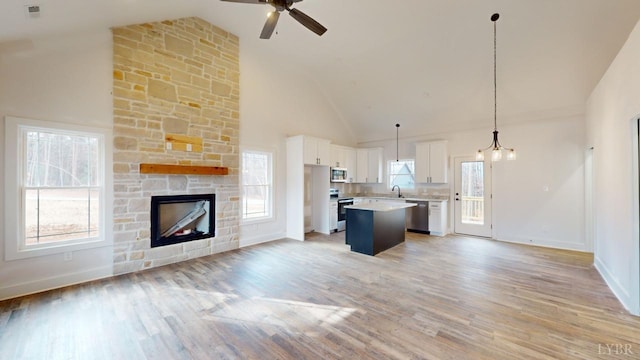 87 Greenhouse Rd, Rustburg, VA 24588 - unfurnished living room with a ceiling fan, a stone fireplace, high vaulted ceiling, baseboards, and light wood finished floors