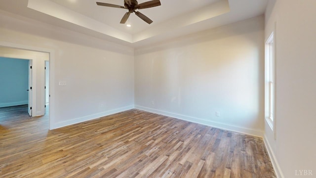 87 Greenhouse Rd, Rustburg, VA 24588 - spare room featuring baseboards, ceiling fan, a tray ceiling, and wood finished floors