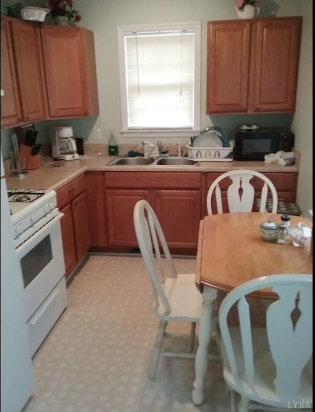 7084 Hunting Creek Rd, Nathalie, VA 24577 - kitchen with light floors, light countertops, a sink, black microwave, and white range with gas cooktop
