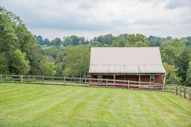 view of outbuilding with an outbuilding, a wooded view, and an exterior structure