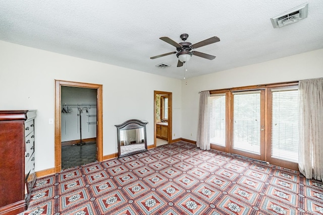 interior space featuring visible vents, ceiling fan, and a textured ceiling